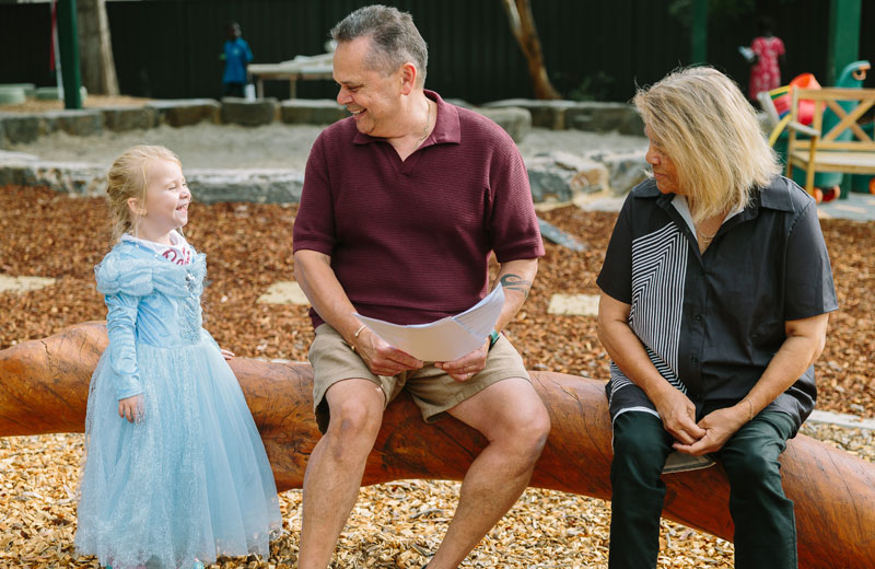 Two preschool educators smiling with a child