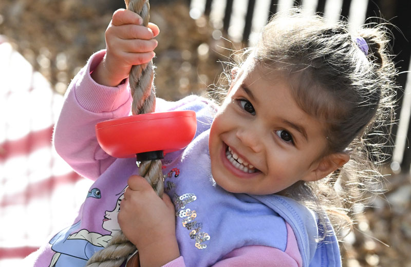 Child with a purple jumper playing outside