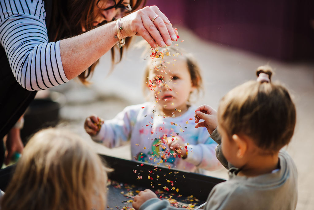 Educator and children sprinkling confetti 