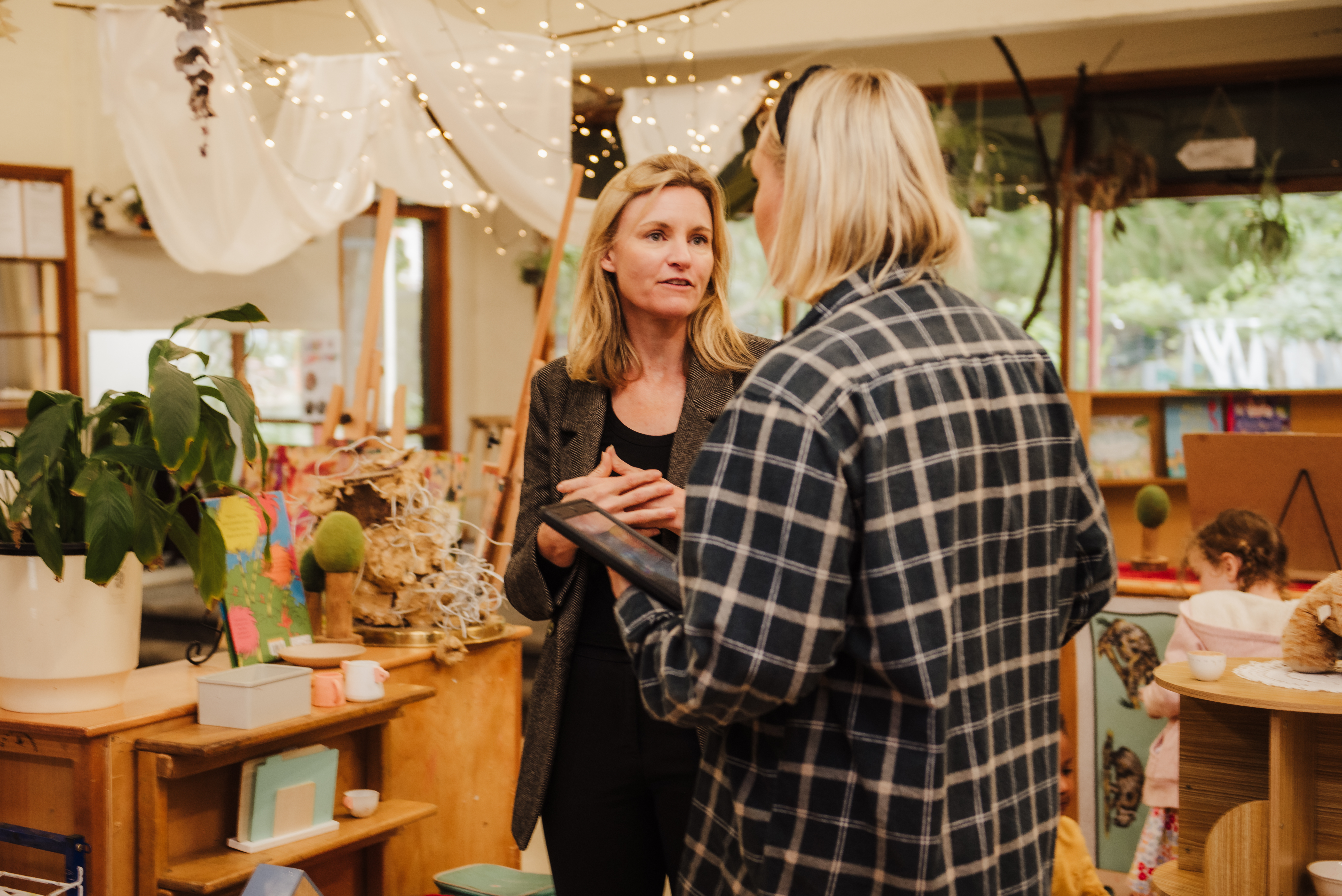 Two staff members at a childcare centre discussing their day