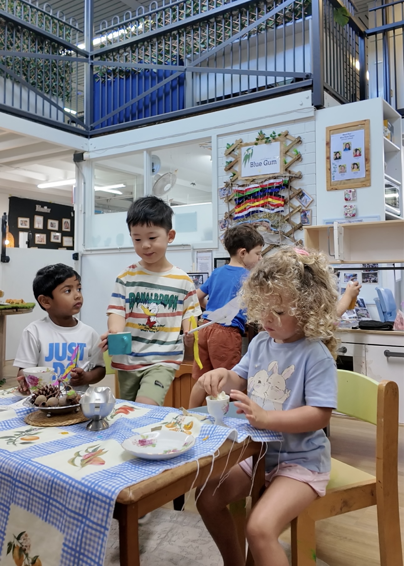 Three children playing at a tea party table at child care